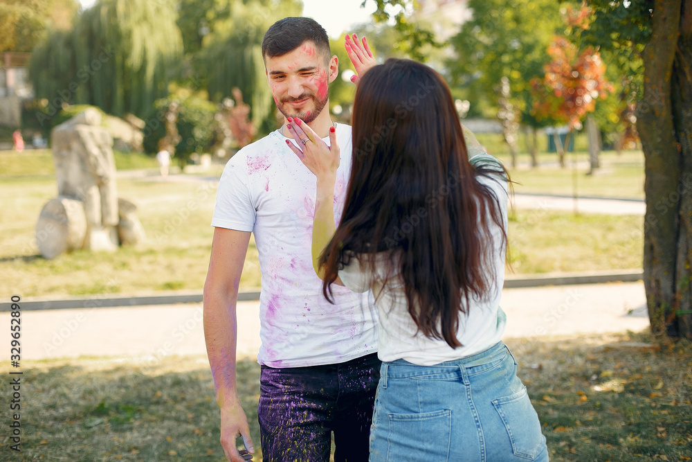 Fototapeta premium Friends with a holi paints. People in a summer park. Students have fun.