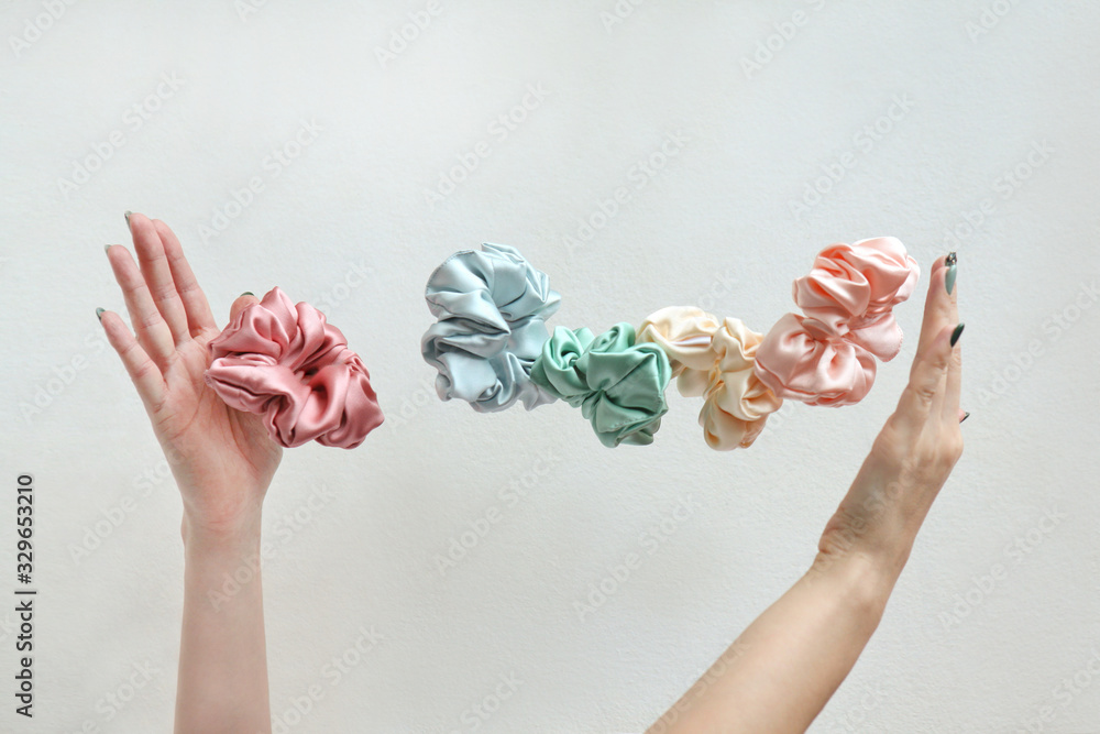 Lot of floating Colorful silk Scrunchies on woma hands isolated white.  Hairdressing tools and accessories. Hair Scrunchies, Elastic Hairbands,  flying or falling Scrunchies Stock Photo | Adobe Stock