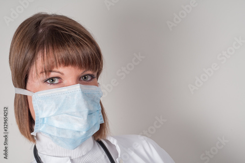 Portrait of female doctor with protection mask isolated on white  © Peter Maszlen