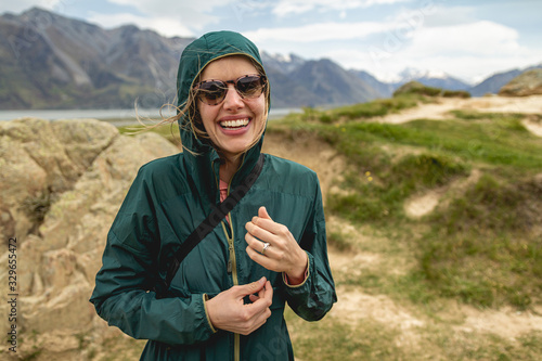 A young woman hiking in a windy valley in New Zealand, home to Mount Sunday