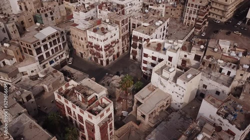 Tilting drone footage of beautiful architecture of old (both neglected and renovated) houses in Al Balad district in Jeddah, Saudi Arabia photo