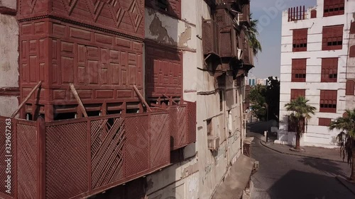 Drone flight past historic merchant houses made of coral stones and carved wood in Jeddah (two pigeons fly away in the shot) photo