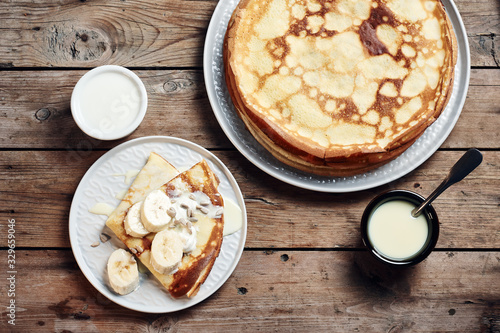 Thin pancakes, crepes with bananas and condensed milk.