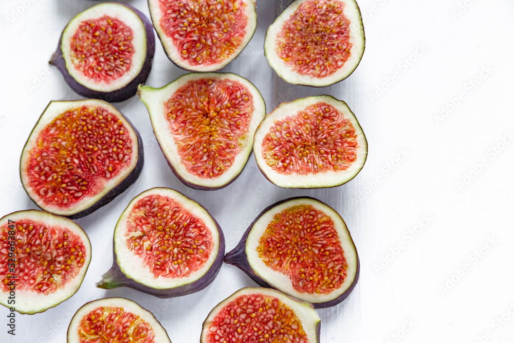 Sliced figs on a light background. Healthy fruits. Nutrition with diet, vegetarianism, healthy nutrition. Flat lay, top view. Sliced figs on a light background. Healthy fruits. Nutrition with diet, vegetarianism, healthy nutrition. Flat lay, top view.