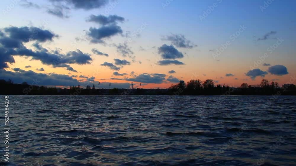 Beautiful sunset over a lake. Waves to the camera. silhouette of the horizon with trees in the background. Beautiful sunset over a lake. Waves to the camera. silhouette of the horizon with trees in the background.