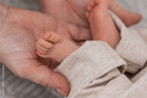 cute and little legs of a newborn baby on a light background 
