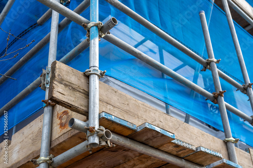 scaffolding poles and screen on a building on a construction site or building site