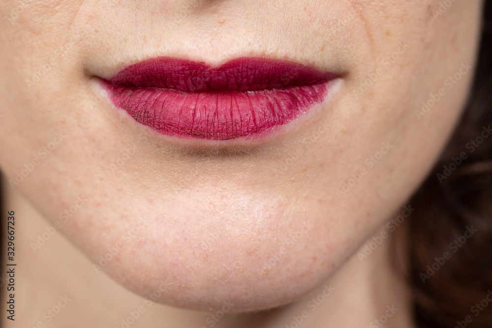 Close up view of nice sensual woman lips with red matt lipstick. Woman smiling. Cosmetology, drugstore and fashion makeup concept... Close up view of nice sensual woman lips with red matt lipstick. Woman smiling. Cosmetology, drugstore and fashion makeup concept...