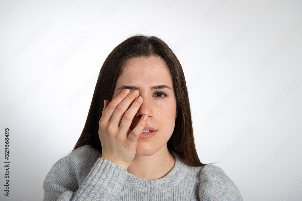 Young brown haired female model portrait. Girl hiding part of her face by hand. Isolated on white background... Young brown haired female model portrait. Girl hiding part of her face by hand. Isolated on white background...