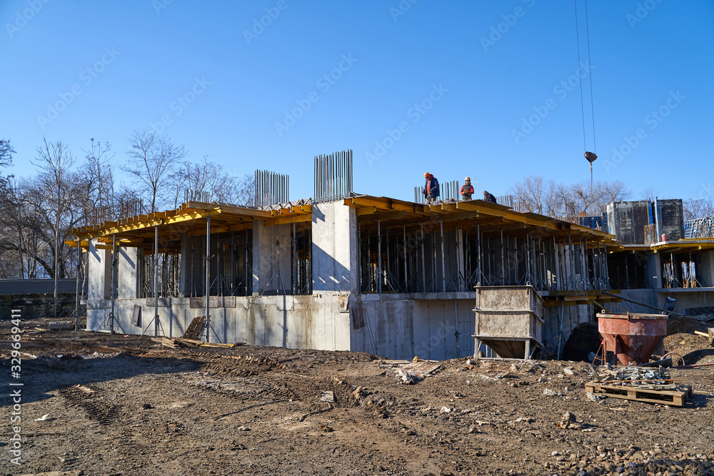 Fototapeta premium Construction site. High rise Building under construction. Construction of high-rise residential building
