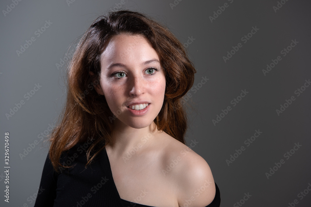 Sensual view of attractive young women. Brunette girl with bared shoulder looking at camera. Isolated on grey background... Sensual view of attractive young women. Brunette girl with bared shoulder looking at camera. Isolated on grey background...