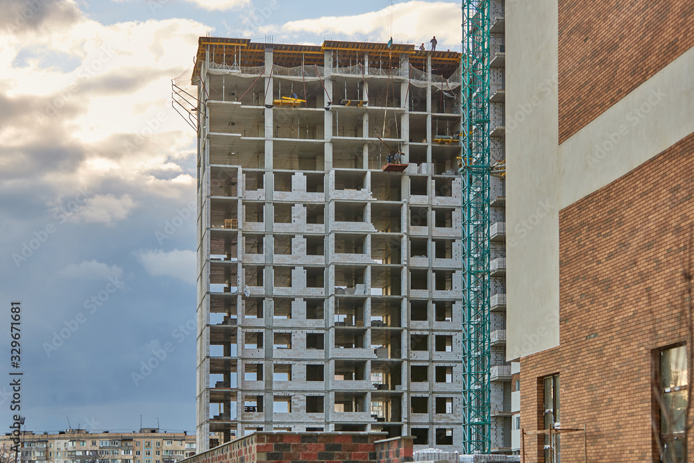 Fototapeta premium Construction site. High rise Building under construction. Construction of high-rise residential building