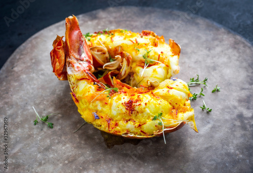 Photos Traditional barbecue spiny lobster tail sliced and offered with saffron lemon sa