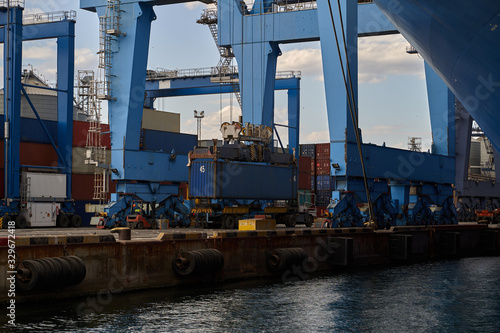 industrial port with containers. .Terminal crane loads container on ship