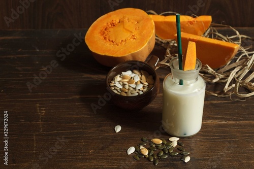 serving vegetable milk without animal fats from pumpkin on a dark wooden table,view from above