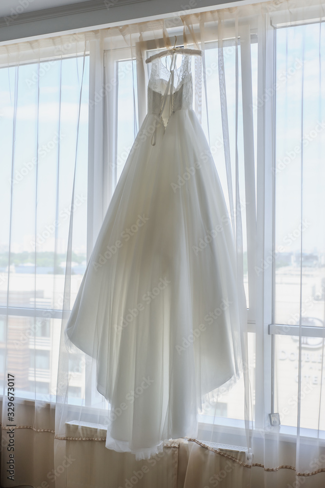 Wedding dress on a window. Happy marriage and bride at wedding day concept Wedding dress on a window. Happy marriage and bride at wedding day concept