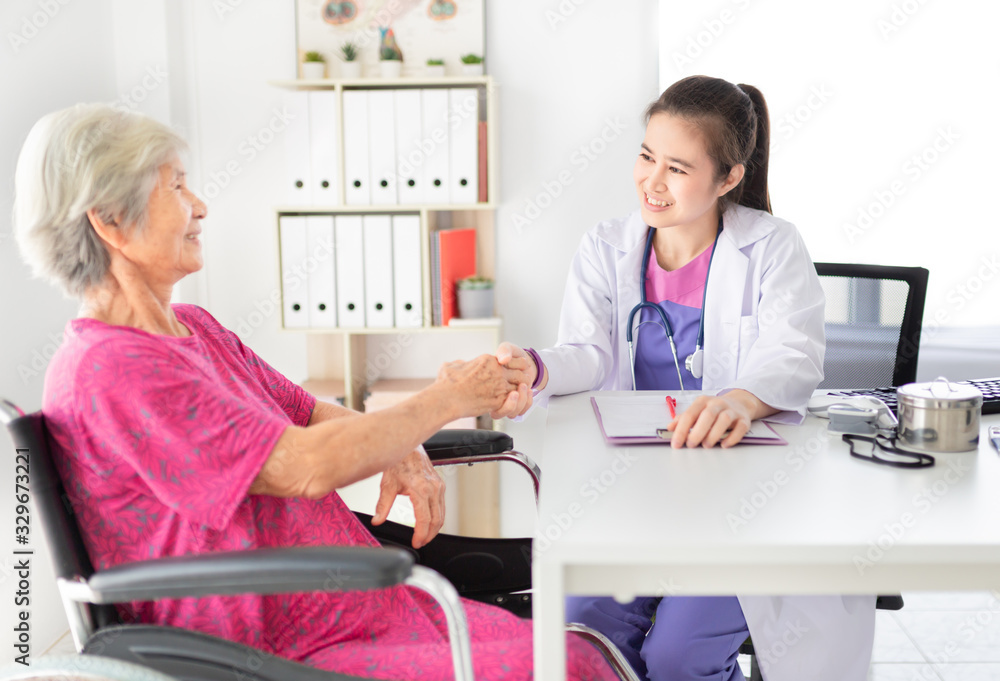 Fototapeta premium Asian doctor talk with old female patient about disease symptom, they holding hand together, elderly health check up, happiness hospital