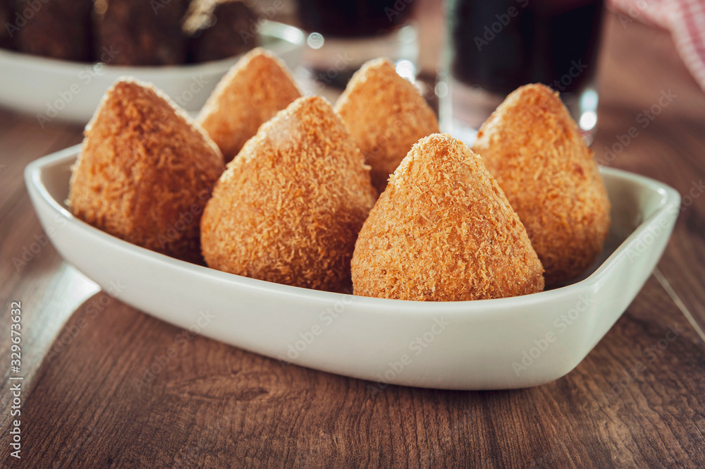 Brazilian appetiser coxinha de frango, kibbe and two glass of soft drink Brazilian appetiser coxinha de frango, kibbe and two glass of soft drink