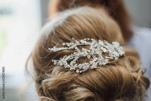 Bridal wedding hairstyle. Tender wedding stylish hairstyle. Elegant bride standing back with collected up do hair. Fine art wedding. Light bridal morning preparation.