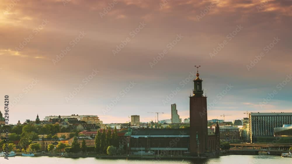 Stockholm, Sweden. Scenic Skyline View Of Famous Tower Of Stockholm City Hall. Building Of Municipal Council Stands On Eastern Tip Of Kungsholmen Island. Famous And Popular Place In Sunset Stockholm, Sweden. Scenic Skyline View Of Famous Tower Of Stockholm City Hall. Building Of Municipal Council Stands On Eastern Tip Of Kungsholmen Island. Famous And Popular Place In Sunset