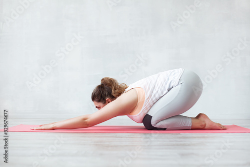 Lovely woman doing stretching or yoga exercise