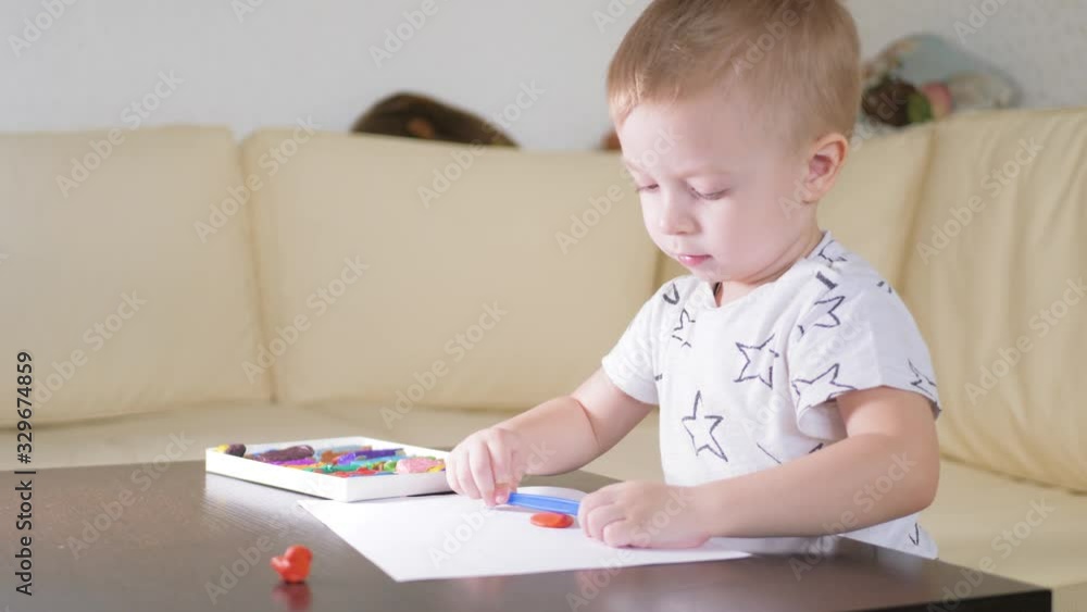 Kid boy playing with plasticine at home. Creative kid with play clay molding at the table. Kid boy playing with plasticine at home. Creative kid with play clay molding at the table.