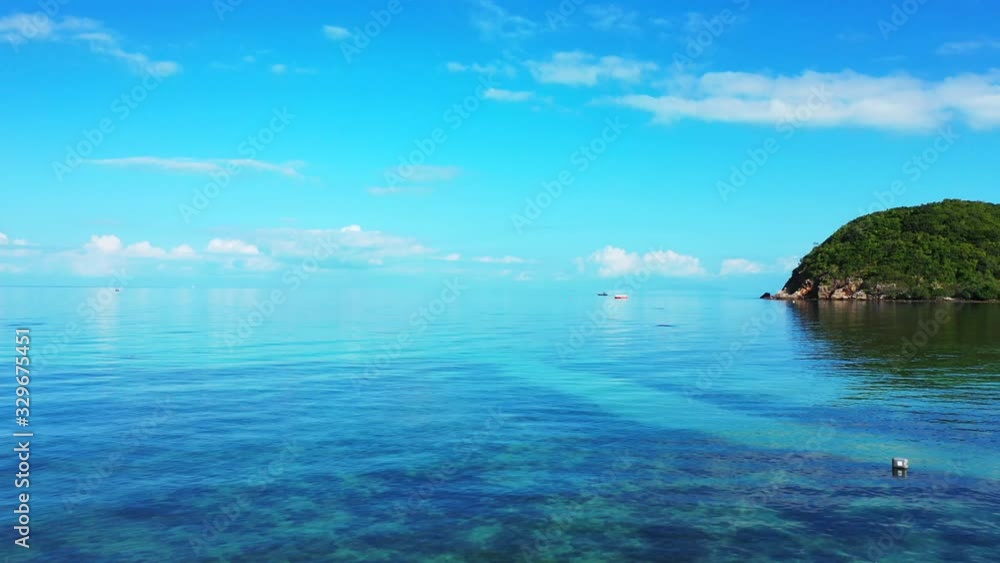 Bright blue sky with beautiful white clouds reflecting on glassy calm sea surface near shore of tropical island Bright blue sky with beautiful white clouds reflecting on glassy calm sea surface near shore of tropical island