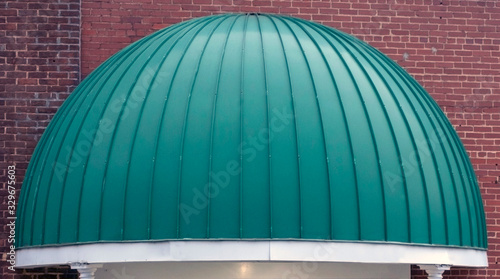 Green dome shaped awning entrance to urban hotel.