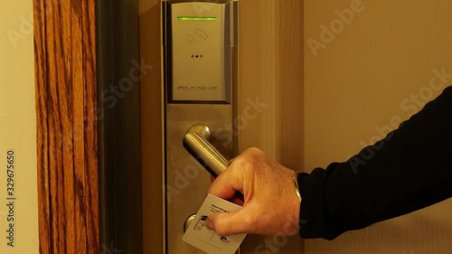 Womans hand uses hotel key card and door handle to enter the room, in close up clip.