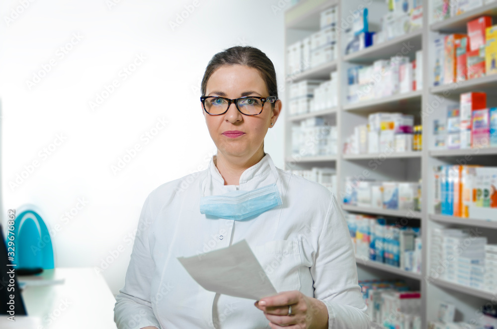 Professional young pharmacist at work looking at camera 