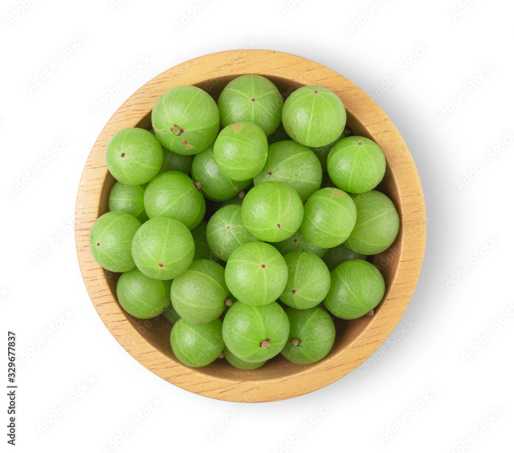 Indian gooseberry in a separate wooden bowl on a white background, top view Indian gooseberry in a separate wooden bowl on a white background, top view