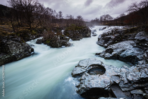 the waterfalls in Glen Orchy near Bridge of Orchy in the Argyll region of the highlands of Scotland during winter whilst the river is flowing fast from rainfall