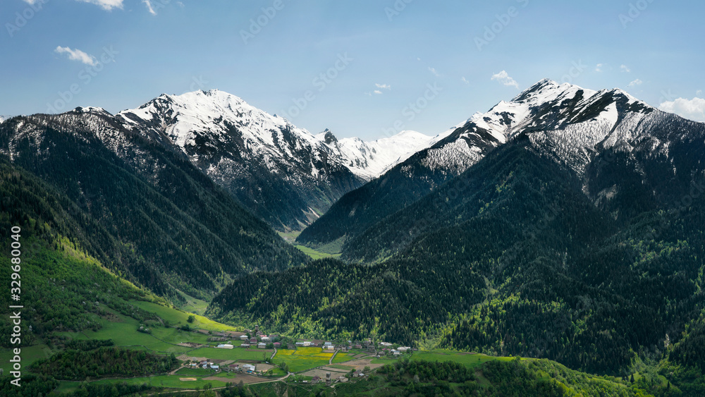 Village among the mountains, green meadows and snow Svaneti