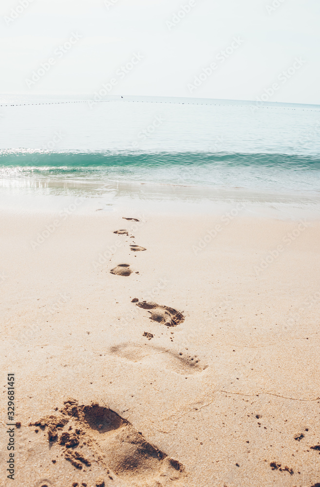 Holiday symbol of quiet rest in attractive areas on the beach, with visible footprints in the sand. Concept for travel vacation - footsteps in sand on summer tropical getaway holidays vacation Holiday symbol of quiet rest in attractive areas on the beach, with visible footprints in the sand. Concept for travel vacation - footsteps in sand on summer tropical getaway holidays vacation