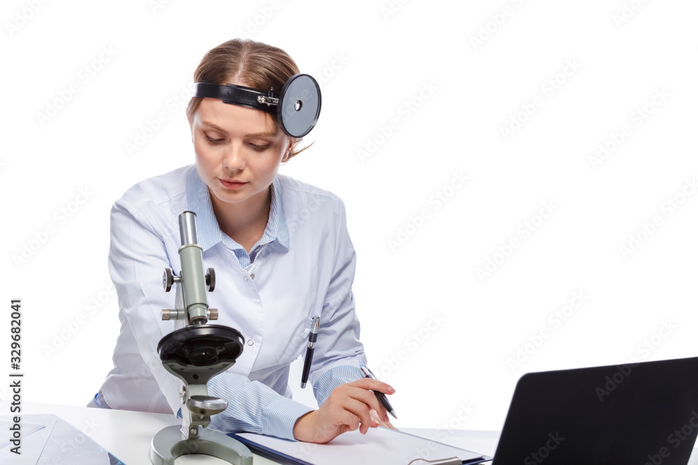Healthcare Concepts. Professional Laboratory Female Researcher in Smock Working With Microscope While Conducting a Research and Making Notes. Healthcare Concepts. Professional Laboratory Female Researcher in Smock Working With Microscope While Conducting a Research and Making Notes.