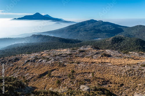  paisaje de volcanes entre las nuebes, montañas entre las nubes  con cielo color azul