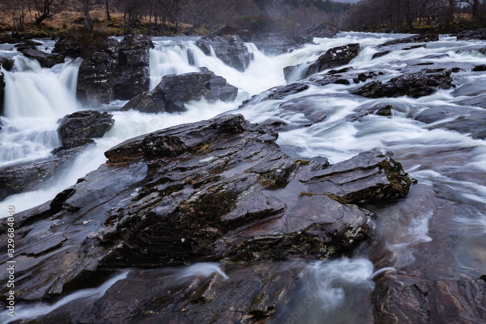 the waterfalls in Glen Orchy near Bridge of Orchy in the Argyll region of the highlands of Scotland during winter whilst the river is flowing fast from rainfall