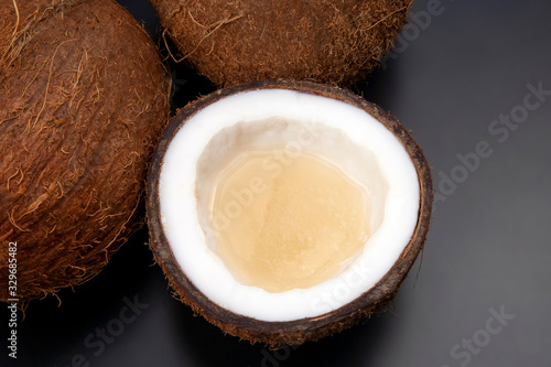 cut fresh coconut with real coconut milk on a dark background. vitamin fruits. healthy food