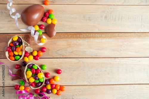 Chocolate eggs for easter holiday. Sweets and ribbons on a wooden background.