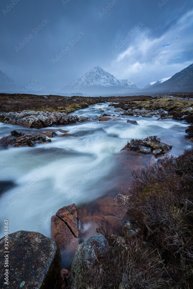 the river coupall waterfalls on rannoch moor showing buachaille etive mor in the background as the entrance to glencoe valley in winter