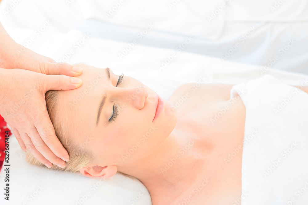 Beautiful woman receiving head and facial massage in spa salon. Concept of body health care and traditional thai massage relax Beautiful woman receiving head and facial massage in spa salon. Concept of body health care and traditional thai massage relax