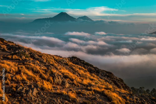 paisaje de volcanes entre las nuebes, montañas entre las nubes con cielo azúl