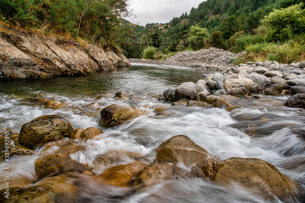 Powerful cascade of water in the river rapids in the natural remote desolated native bush of the Forest ranges of Tararua district Powerful cascade of water in the river rapids in the natural remote desolated native bush of the Forest ranges of Tararua district