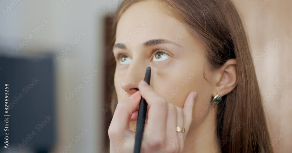 makeup artist makes makeup to young girl and sinks bags under model eyes makeup artist makes makeup to young girl and sinks bags under model eyes