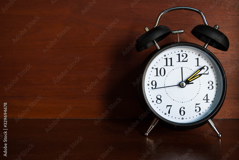 Black retro alarm clock on wood table background with copy space Black retro alarm clock on wood table background with copy space
