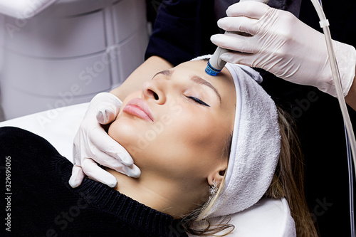 Face cleansing, serum vacuum hydro-peeling. young woman enjoys a radiant face in a beauty salon, cosmetic facial skin care, professional doctor, freshness and modern technology
