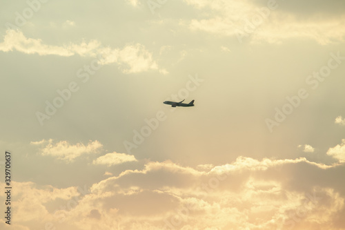 Paisaje minimalista con avión sobrevolando en una atardecer con colores cálidos © Huitshot