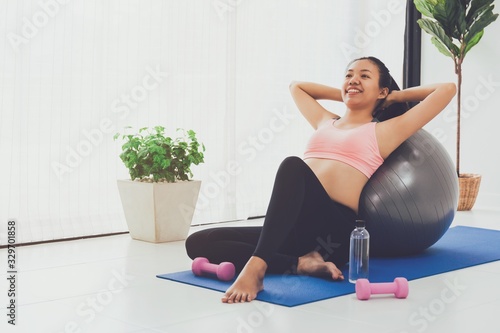 Asian woman resting after play yoga and exercise at home background with copy space.Exercise for Lose weight, increase flexibility And tighten the shape.