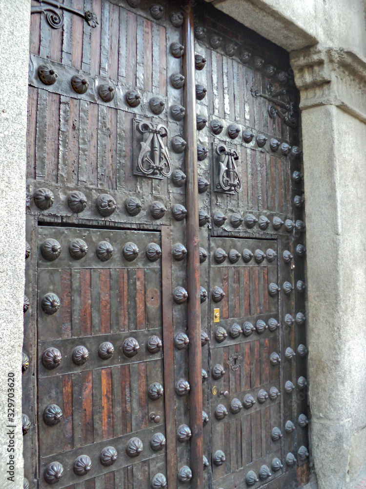 Ancient door in a building in Madrid, Spain. A unique detail of a beautiful old Spanish building. Ancient door in a building in Madrid, Spain. A unique detail of a beautiful old Spanish building.