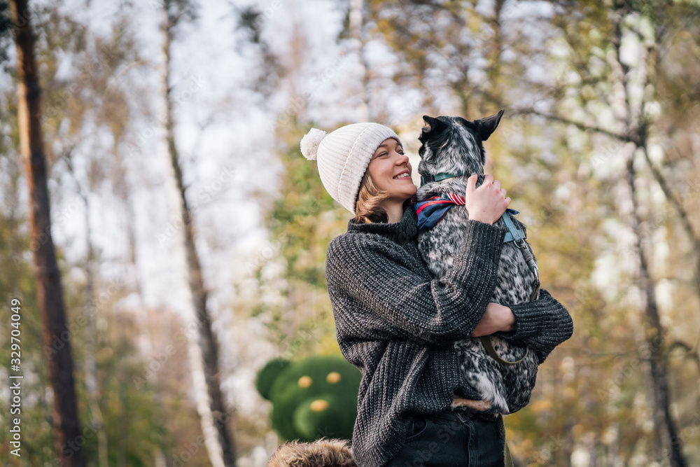 A girl is holding a mongrel dog in her arms. Caring for animals. A girl is holding a mongrel dog in her arms. Caring for animals.